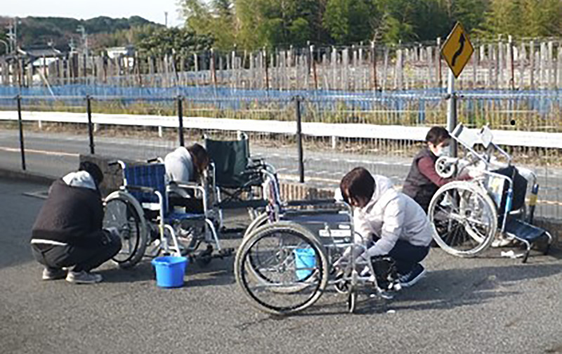 福祉施設で利用者の車いすを清掃する社員ボランティア