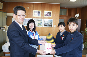 （左側手前より）二ノ宮雄三さん（新車進行管理室）、松田由美さん（総務室）からボランティア委員の児童代表2名に寄贈された